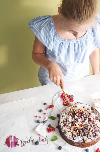 Der Beerenkuchen wird von Liv mit einem goldenen Messer angeschnitten.