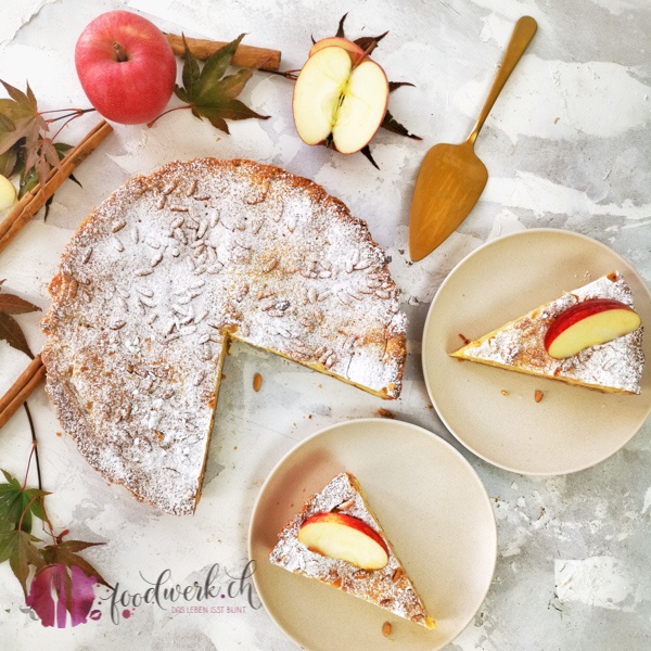 Torte della Nonna mit Apfel und Pinienkernen aufgeschnitten auf einem Teller von oben fotografiert