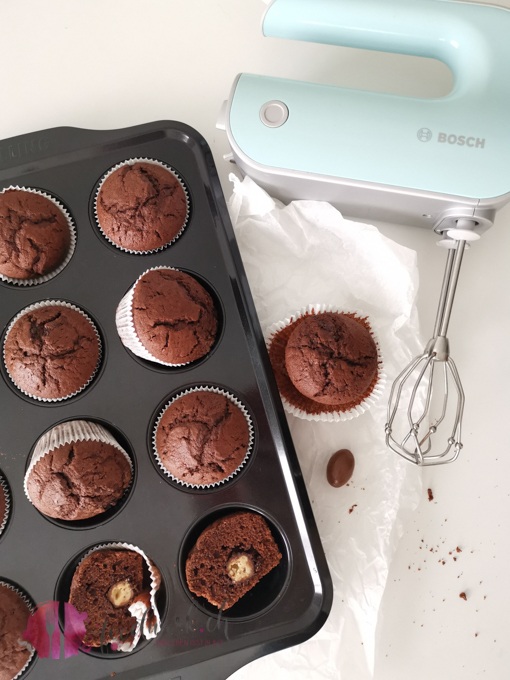 Schokoladenmuffins und Bosch Handrührgerät. Die Muffins sind mit Schokobons gefüllt.