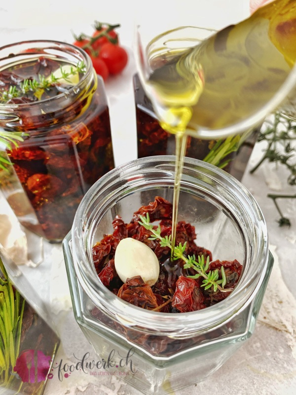 Olivenöl zu den getrockneten Tomaten im Glas geben