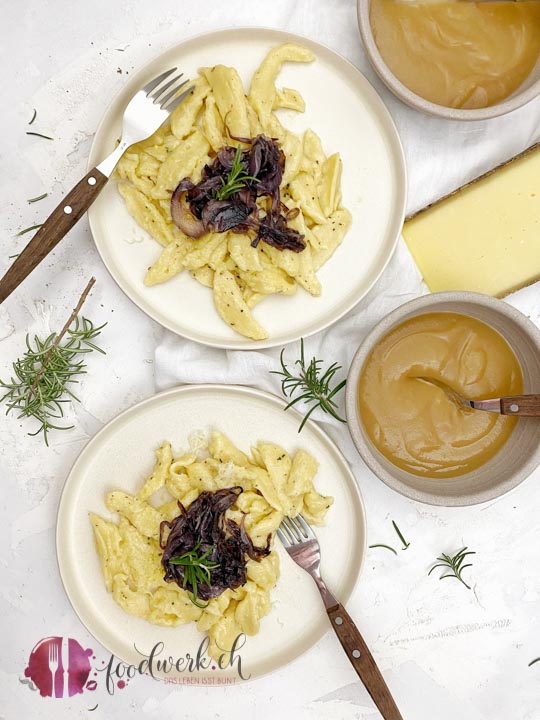 Quarkpizokel auf zwei Tellern mit Zwiebelschweize und Apfelmus sowie Schweizer Bergkäse