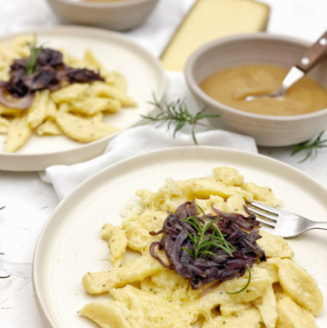 Quarkpizokel auf hellem Teller mit Zwiebelschweize und Apfelmus