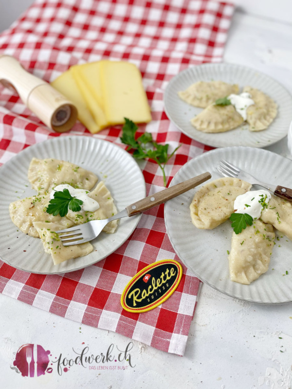 Pierogi mit Raclettesuisse auf rot kariertem Tuch