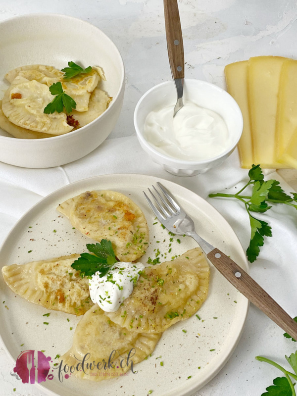 portion pierogi mit raclette kaese auf teller