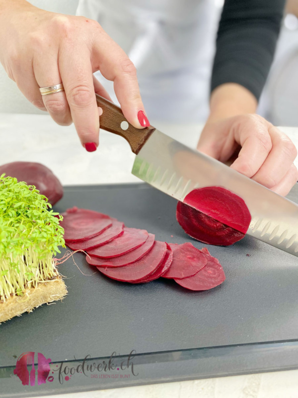 Die gekochten Randen mit einem Victorinox Santoku Messer schneiden