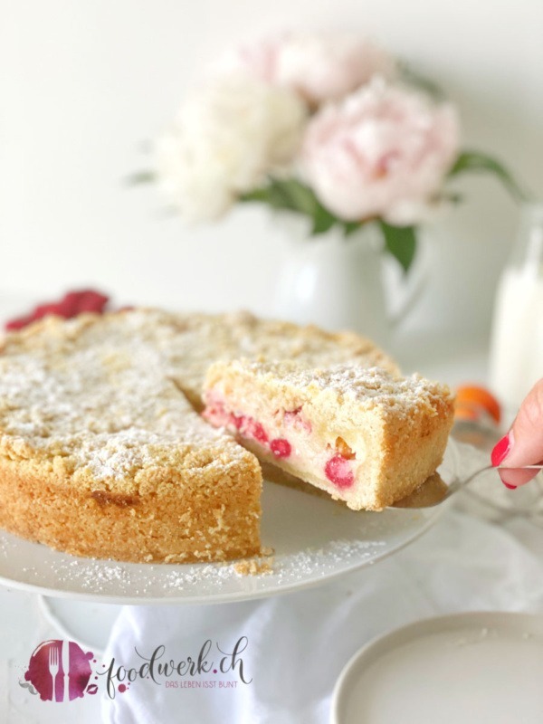 Streuselkuchen auf Tortenplatte mit Aprikosen und Himbeeren