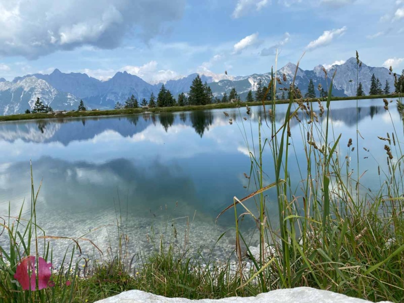 Kaltwassersee mit Bergen im Hintergrund