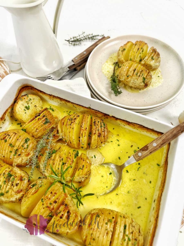 Knoblauch Schmelzkartoffle in der Gratinschale und geschöpft auf einem kleinen Tellern