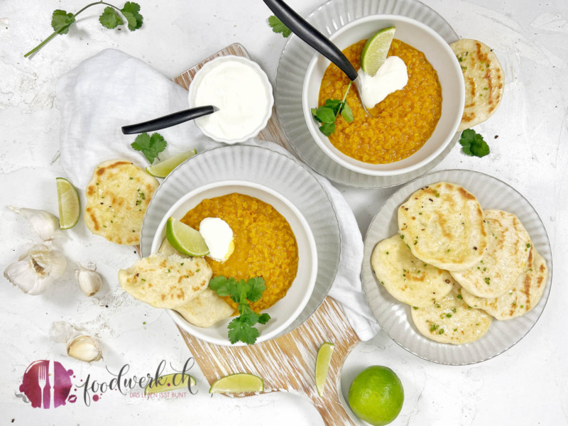 Linsen Dal angerichtet in weissen Schalen mit Naan Brot