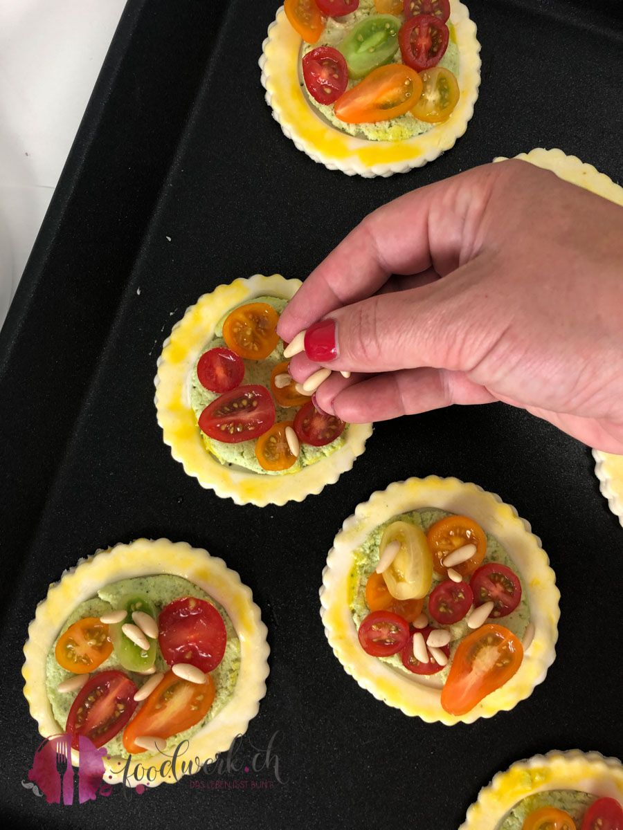 Pinienkerne auf die Tomaten legen