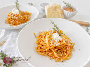 Zwei Teller mit Pasta al Gusto Blitzrezept, Pinienkernen und Parmesan