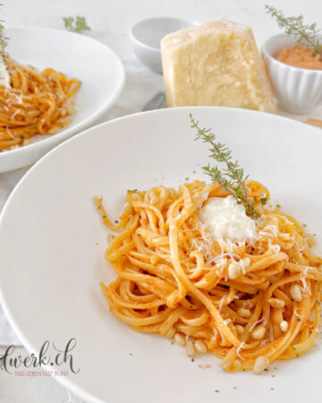 Zwei Teller mit Pasta al Gusto Blitzrezept, Pinienkernen und Parmesan